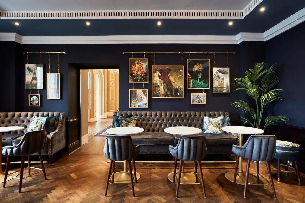 a restaurant with blue walls and tables and chairs at The Clermont London, Charing Cross in London